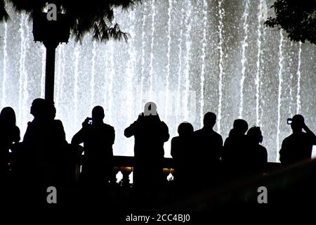 Scena notturna con sagome di persone che ammirano lo spettacolo delle fontane Bellagio a Las Vegas, Nevada Foto Stock