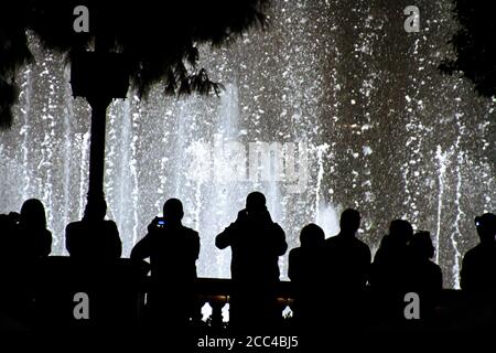 Scena notturna con sagome di persone che ammirano lo spettacolo delle fontane Bellagio a Las Vegas, Nevada Foto Stock