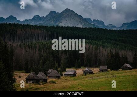 Percorso attraverso la Valle di Gasienicowa nelle montagne di Tatra, Polonia. Maltempo autunno su belle case di legno nei prati ai piedi delle colline. Foto Stock