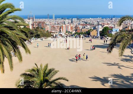 Barcellona, Spagna. Il Parc Güell. Gran Plaça circolare. Il Central Plaza. Paesaggio urbano di Barcellona in background. Parco Guell è stato progettato da Antoni Gaudi Foto Stock