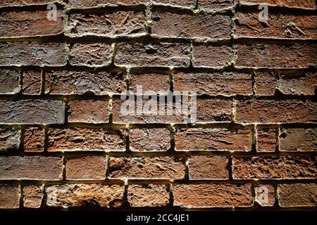 primo piano di un muro di mattoni illuminato di notte da proiettori Foto Stock