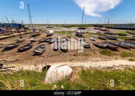 Leigh Marsh Off Old Leigh, a Leigh on Sea, Essex, UK, con bassa marea. Barche a remi, gommoni legati a catene di ormeggio. Barche. Riva, costa Foto Stock