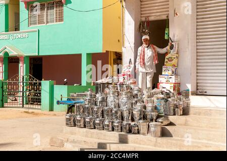 Puttaarthi, Andhra Pradesh, India - 13 gennaio 2013: Venditore di pentole, padelle, utensili e vari articoli in acciaio per la cucina nel villaggio di Puttaarthi. Foto Stock