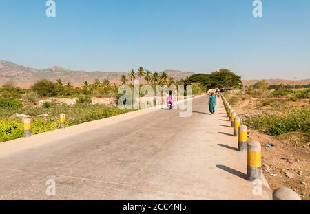 Puttaarthi, Andhra Pradesh, India - 11 gennaio 2013: Vista del paesaggio rurale indiano con la strada per il villaggio di Puttaarthi, India Foto Stock