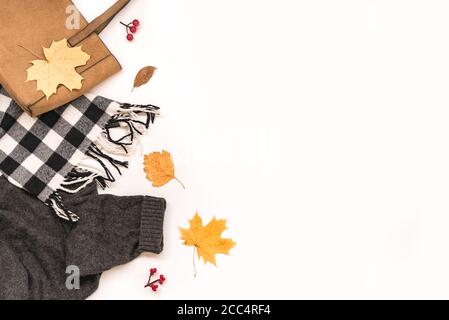 Composizione autunnale - borsa in pelle scamosciata, sciarpa e maglione comodi, foglie autunnali isolate su sfondo bianco, posa piatta, vista dall'alto, spazio per la copia. Autunno stagionale Foto Stock