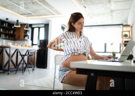 Donna incinta che lavora da casa. Carriera e concetto di gravidanza Foto Stock