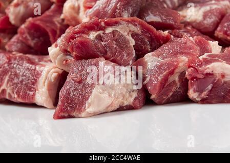 Carne di maiale grezza tritata su vetro bianco da vicino. Foto Stock