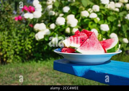 fette di anguria matura su un piatto nel giardino Foto Stock