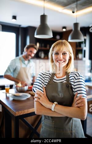 Coppia felice per la cottura di alimenti sani e divertirsi insieme nella loro cucina Foto Stock