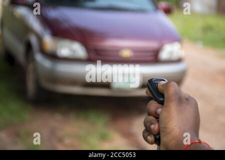 Messa a fuoco selettiva di una persona nera utilizzando un'auto telecomando per sbloccare un'auto Foto Stock