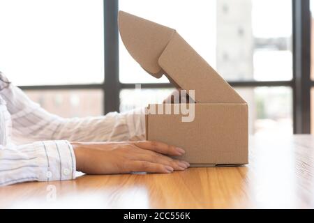 Donna apertura scatola con nuovo pacco, primo piano Foto Stock
