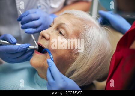 Manipolazioni mediche in odontoiatria sulla bella paziente femminile Foto Stock