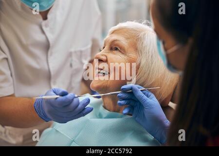 Dentista e il suo assistente di effettuare un esame approfondito Foto Stock