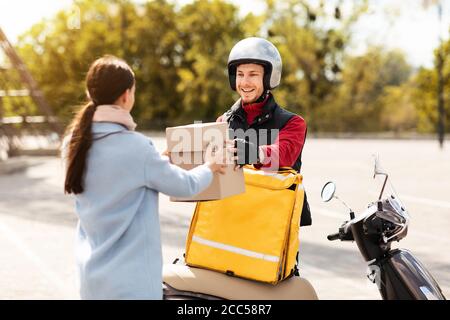 Corriere Guy consegna pacchi al cliente all'aperto Foto Stock