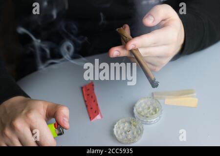 Fumare cannabis in carta smussata, uso ricreativo di marijuana Foto Stock