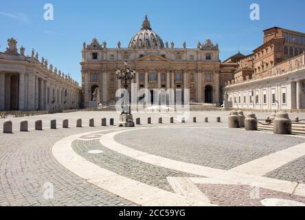 Piazza San Pietro e la Basilica di San Pietro a Città del Vaticano in una chiara giornata estiva. La piazza acciottolata è vuota di gente e turisti. Foto Stock