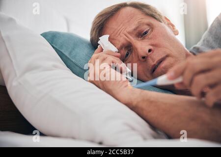 Foto focalizzata sull'uomo emozionale che controlla il risultato Foto Stock