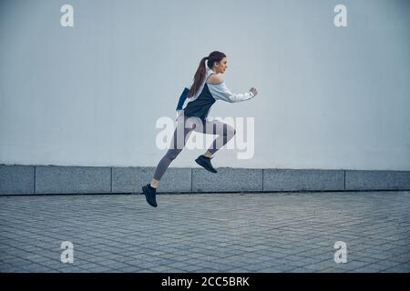 Donna sportiva seria che galleggia attraverso l'aria Foto Stock