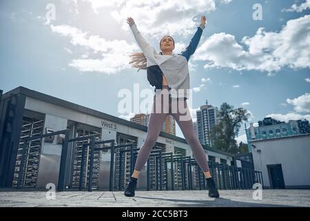 Giovane femmina caucasica che allunga il suo corpo all'aperto Foto Stock