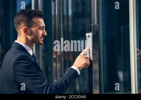 Uomo serio bruna cercando di entrare in costruzione Foto Stock