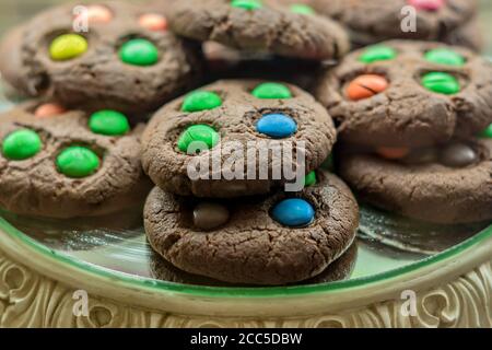 Biscotti dolci al cioccolato con caramelle colorate su un display, fuoco selettivo Foto Stock