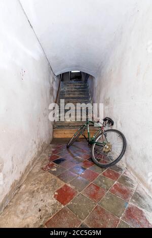 un corridoio in una vecchia casa con scale e biciclette dentro Il quartiere ebraico di Třebíč Foto Stock