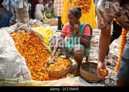 I venditori vendono al mercato dei fiori di Mullick Ghat a Kolkata (Calcutta), India, riforniscono molti dei fiori che decorano i templi della regione. Foto Stock