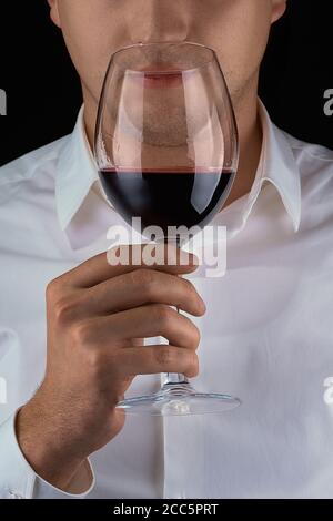 L uomo lo sniffing di vino rosso in un bicchiere, close up Foto Stock