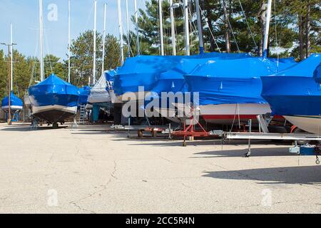 Tarp blu protettivo sulle barche nel Michigan deposito all'aperto Foto Stock