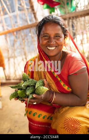 Una donna si siede nella sua cucina con zucca amara appena raccolta, prelevata dalla sua fattoria a Bihar, India, Asia meridionale. Foto Stock