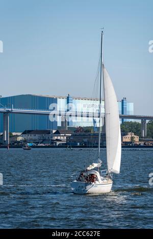 Stralsund, Germania. 13 Agosto 2020. Una barca a vela naviga sullo Strelasund, un'insenatura del Mar Baltico. Alle sue spalle si può ammirare il Ponte Rügen e i cantieri MV di Stralsund. Credit: Stefano Nosini/dpa-Zentralbild/ZB/dpa/Alamy Live News Foto Stock