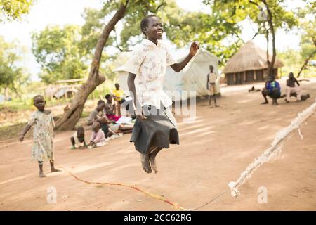 I bambini rifugiati sudanesi saltano la corda insieme nel campo profughi di Palabek, nel nord Uganda, Africa orientale. Foto Stock