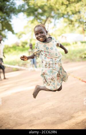 I bambini rifugiati sudanesi saltano la corda insieme nel campo profughi di Palabek, nel nord Uganda, Africa orientale. Foto Stock