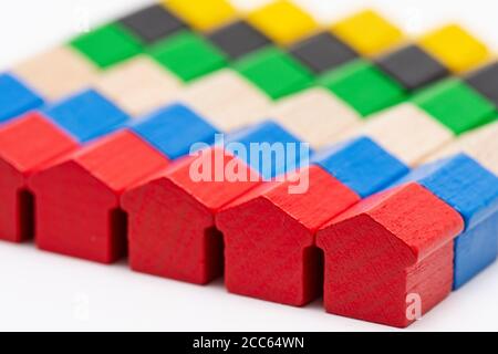 File di minuscole case di giocattoli in legno dipinte in diversi colori Foto Stock