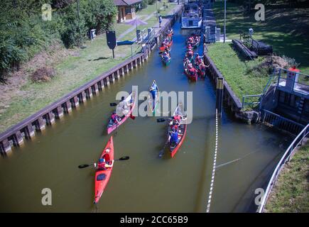 06 agosto 2020, Meclemburgo-Pomerania occidentale, Diemitz: Un gruppo di pagaioli sta navigando nella chiusa di Diemitz, nel distretto dei laghi di Meclemburgo. Migliaia di vacanzieri stanno attualmente viaggiando in barca, in bicicletta o a piedi nel distretto dei laghi di Mecklenburg. Foto: Jens Büttner/dpa-Zentralbild/ZB Foto Stock