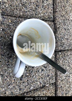 Svuotare la tazza di caffè sul terreno Foto Stock
