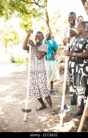 Un gruppo di agricoltori posa con le zane che hanno ricevuto per aiutare con le loro abilità agricole nell'insediamento dei rifugiati di Palabek nel nord Uganda, Africa orientale. Foto Stock