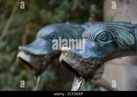 Antica fontana tradizionale della regione francese di Dauphiné con rubinetti a forma di teste stilizzate di delfini, Montmaur, Hautes-Alpes, Francia Foto Stock