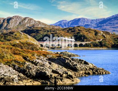 Treno a vapore Jacobite che passa sopra il viadotto di Loch nan Uamh vicino Arisaig Highland Scotland UK in direzione di Fort William Foto Stock