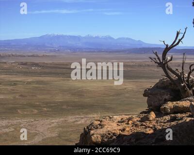 Vista sulle aride pianure orientali dello Utah con le sgargianti montagne innevate di la SAL sullo sfondo in una giornata di sole Foto Stock