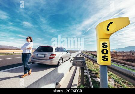Punto di servizio SOS sull'autostrada - il conducente donna ha un problema con la vettura Foto Stock