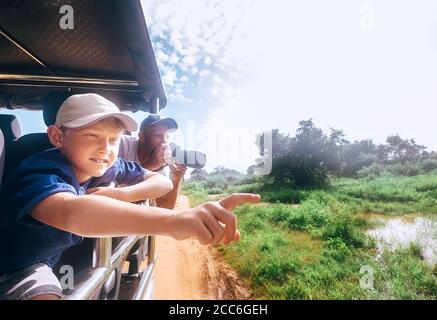 Figlio e padre videro gli animali in safari in natura parcheggio Foto Stock