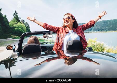 Due fidanzate che viaggiano in cabriolet Foto Stock