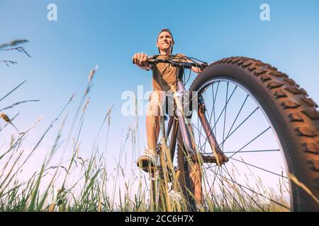 Uomo che inizia a fare un giro in bicicletta Foto Stock