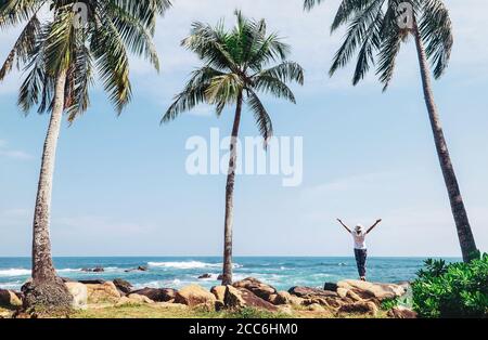 Punta meridionale isola Sri Lanka - capo Dondra, donna si trova sulla costa e guarda in linea orizzontale Foto Stock