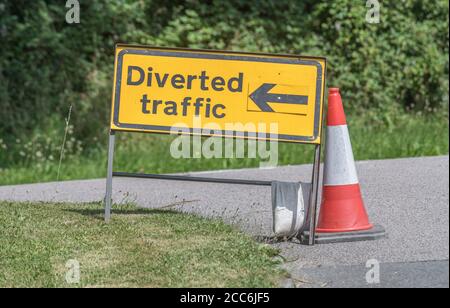 Sistema di trasporto stradale per il Regno Unito. Segnale stradale deviato con freccia direzionale. Per la chiusura temporanea delle strade, segnaletica stradale UK. Foto Stock