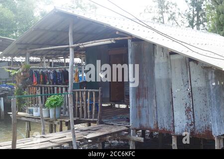 Casa palafitte sull'acqua in un villaggio di pescatori thailandese Foto Stock