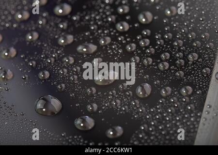 gocce d'acqua sulla superficie del vetro con rivestimento idrofobico del cellulare schermo Foto Stock
