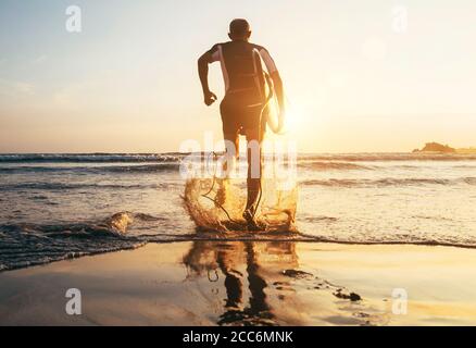 Surfista con surf corre alle onde oceaniche Foto Stock