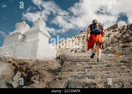 L'uomo turistico sale le scale fino al luogo sacro tibetano in Montagna Himalaya Foto Stock